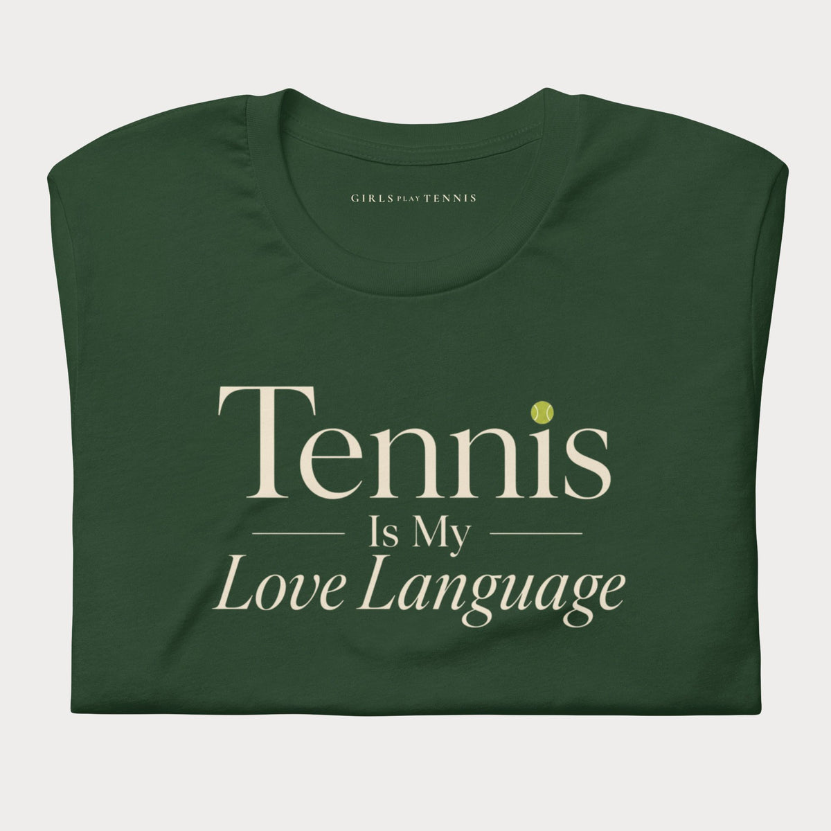 Folded forest green Tennis Is My Love Language women's tennis T-shirt with cream serif lettering and a tennis ball dot