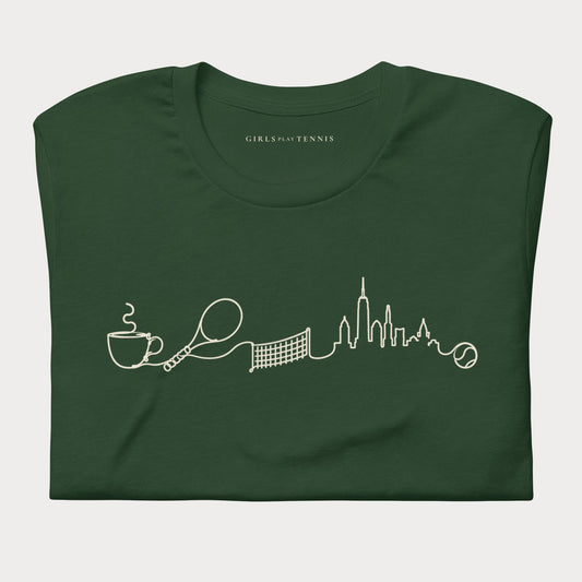 Folded forest green The Long Rally women's tennis T-shirt with a line drawing of a coffee cup, racket, net and city skyline